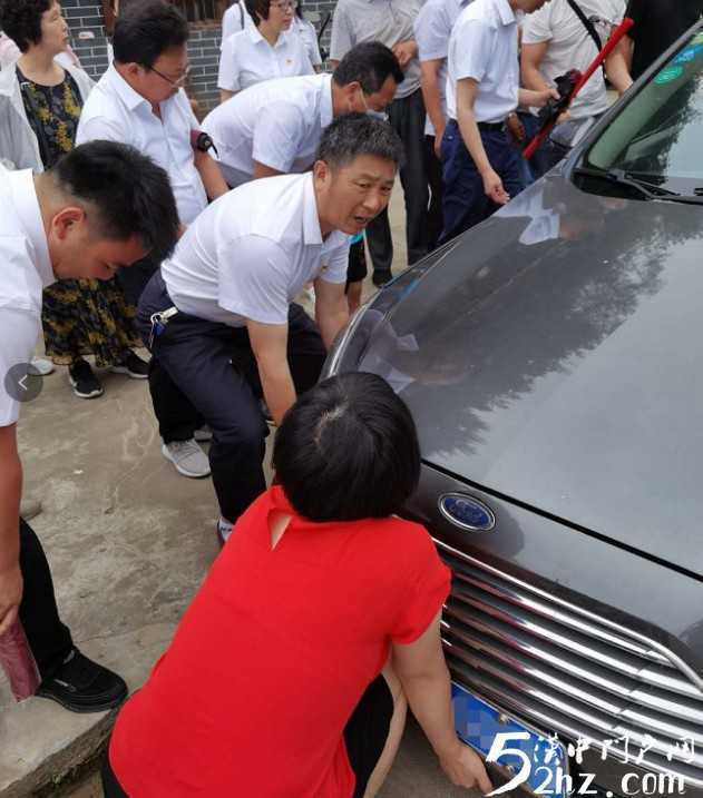 女司機開車掉進溝里，洋縣眾黨員幫忙抬車